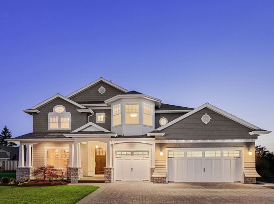 A large house with two garage doors and a driveway.